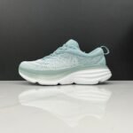 Light blue running shoe on a reflective surface with a dark background
